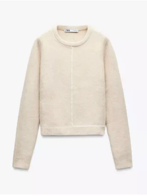 Beige stickad tröja från Zara - Säljer en stilren beige stickad tröja från Zara med rund halsringning och diskret söm framtill. Tröjan har långa ärmar och ribbade muddar vid ärmslut och nederkant. Perfekt för lager på lager och enkel att matcha. Har många fina detaljer som strecket och slits.