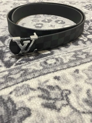  svart rutigt bälte - Svart bälte storlek 120 cm