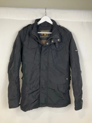 Woolrich Jacka - Tja säljer en snygg svart jacka från Woolrich med krage och detaljer som dragkedjor och knappar framtill. Jackan är i väldigt fint skick och säljs för endast 1399kr. Nypris över 6000kr. Skriv vid frågor eller ifall du vill ha fler bilder. Storlek Small.