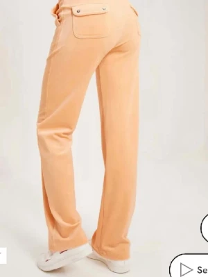 Persikofärgade mjukisbyxor i velour - Persikofärgade Juicy Couture byxor, har fått lite smuts på sig men går att tvätta bort, de är i storlek S, köpta för ca 1100kr säljer för 700kr 