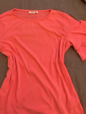 Rosa topp med volangärm från Kappahl  - Trendig rosa topp från KappAhl med rund halsringning och volang ärmar. Perfekt sommar topp 