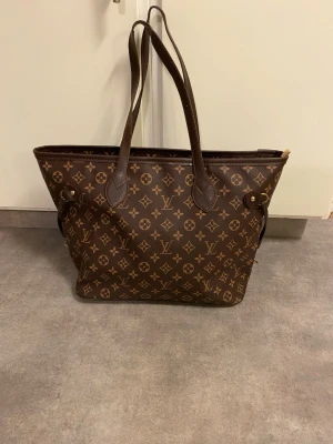 Mönstrad väska - Helt ny, mönstrad väska, som man kan dra igen på sidorna. Har ett stort fack. Stängs med dragkedja. Ser nu att bilden på hur den ser ut inut, blev helt suddig. Man får fler bilder om man vill. Köpt, men bara stått i förrådet. Ca 45cm lång och va 38cm hög.