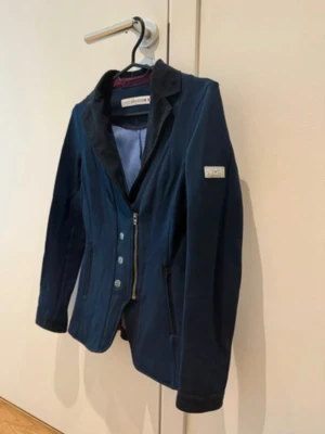 Snygg tävlingskavaj från Animo - Säljer min fina tävlingskavaj från Animo. Marinblå med ljusblå insida. Italiensk storlek men passar xs/xxs. Avnävd fåtals ggr så väldigt bra kvalitet. Annonsen finns på vinted