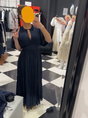 Marinblå långklänning med knyt - Säljer min fina marinblå klänning från Hugo BOSS. Endast använd vid ett tillfälle (bröllop) och passar utmärkt för finare och mer eleganta evenemang, passar utmärkt som en balklänning exempelvis. Klänningen är köpt på Room 1006 och är av äkta vara. Utgångspriset för den var 5299kr och är i storlek xs. 