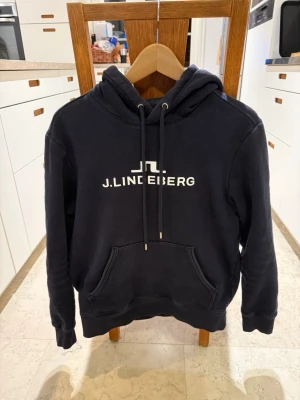 J Lindeberg Hoodie Marinblå - Säljer nu denna hoodie från J Lindeberg i storlek S. Inga defekter men finns tecken på användning. Köpt i butik för 1199 och kan gå ner i pris vid snabb affär😁☺️