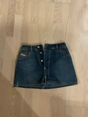 Mörkblå jeanskjol från Diesel - Säljer en mörkblå jeanskjol från Diesel med knappar framtill pga kommer inte till användning längre💗💗💗