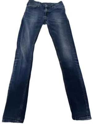 Nudie Jeans W27 L32  - Säljer ett par mörkblåa Nudie Jeans i storlek W27 L32 i mycket bra skick! Riktigt sköna.