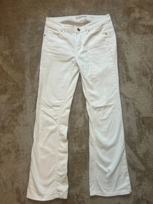 Vita bootcut jeans från Denim - Snygga vita jeans från Denim i modellen Cindy. Byxorna har klassisk femficksdesign, normalhög midja och bootcut-ben.