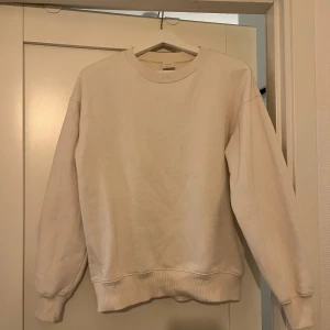 Benvit sweatshirt från Zara - En stilren benvit sweatshirt från Zara i storlek 164. Tröjan har rund halsringning, ribbade muddar och är långärmad. Perfekt för en chill och enkel look. Materialet är mjukt och skönt, troligtvis bomullsmix. (Lite nopprig)