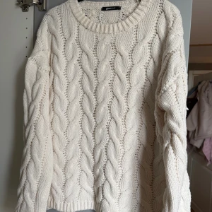 Vit stickad tröja från Gina Tricot - Säljer en vit stickad tröja från Gina Tricot i storlek M. Tröjan har ett snyggt flätmönster, rund hals och långa ärmar. Perfekt för dig som gillar en mysig och stilren look med lite volym i passformen.