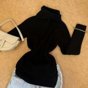 Svart ribbad polotröja XS - Svart polotröja från Gina Tricot i storlek XS. Tröjan är ribbstickad med lång ärm och hög polokrage, vilket ger en snygg och clean look. Perfekt att styla med jeans eller kjol för en chill vibe. Materialet är mjukt och stickat.