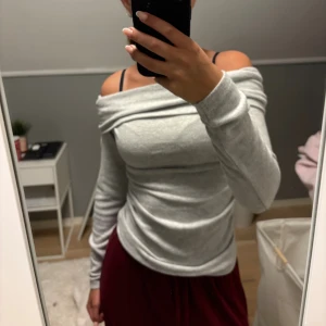 Grå axelfri tröja  - Säljer denna gråa axelfria tröja ifrån new yorker i storlek S. Provad ca 2 gånger men inte använd efter de. Är i ett väldigt gosigt material som värmer väldigt mycket! 