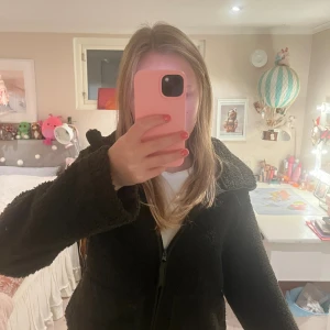 Mörkgrön  teddyjacka med dragkedja - Mysig mörkgrön teddyjacka från H&M med hög krage och hel dragkedja. Perfekt för kyliga dagar och enkel att styla till olika outfits.