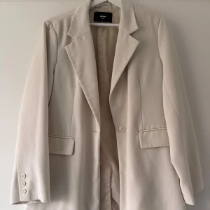 Beige kavaj från bikbok - Beige oversized kavaj från Bik Bok Stilren och tidlös kavaj i en mjuk beige nyans. Modellen är lätt oversized med klassisk krage, enkel knäppning framtill och två fickor med lock. Ärmslut med tre dekorativa knappar. Fodrad insida för en bekväm passform.