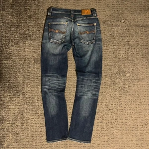 Nudie jeans grim tim - Sjukt snygga och välomhändertagna nudie jeans i modellen grim tim. Brallorna är i mycket bra skick och har en riktigt unik tvätt på både fram och baksida. Storlek W29 L32. W-39cm L-102cm Skriv om det finns några frågor!