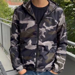 Camo windbreaker/höstjacka -  Säljer en snygg vind/höstjacka från Lindfors i camoflage mönster med dragkedja och huva. Perfekt för de kyligare vädret nu.