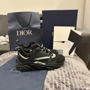 Svarta och vita sneakers med mesh - Bilder på skorna i dm!!!! Snygga svarta sneakers med vita detaljer och sportig design. Skorna har en rund tå, platt sula och snörning. Ovandelen är tillverkad i mesh och syntet för extra komfort och andningsförmåga. Perfekt för dig som gillar en stilren och modern look.