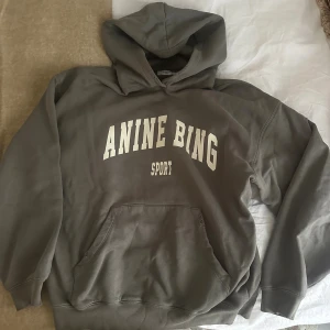 Grå hoodie från Anine Bing - Snygg grå hoodie från Anine Bing Sport med vit text framtill. 
