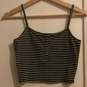 Svartvit randig croppad linnetopp - Säljer en croppad linnetopp med små knappar fram. 
