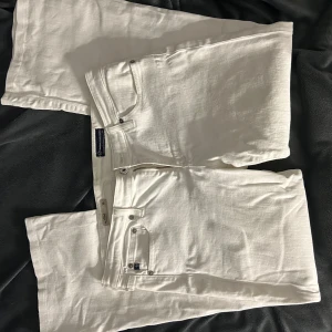 Vita jeansbyxor från Adriano Goldschmied  - Snygga vita jeansbyxor från AG med klassisk femficksdesign och silverfärgade detaljer. Byxorna är bootcut och har tydliga broderier på bakfickorna samt Replay-logga vid linningen. Perfekta för dig som vill sticka ut med en fräsch look.