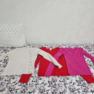 Tre ribbade långärmade tröjor - Säljer tre snygga ribbade tröjor från H&M i storlek S. En vit med dekorativa knappar, en röd med v-ringning och en rosa med djup v-ringning. Alla har lång ärm och är gjorda i mjuk stickad bomullsmix. Perfekt för dig som gillar färg och stil!