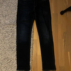 Levi's 511 mörkblå jeans W29 L32 - Snygga mörkblå Levi's 511 jeans med klassisk femficksdesign och raka ben. Jeansen har en smal passform och är tillverkade i slitstarkt denimtyg. Perfekta för dig som gillar en stilren och tidlös look.