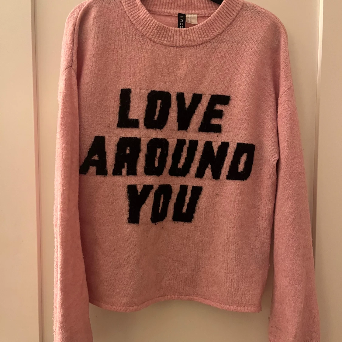 Rosa stickad tröja med text från H&M