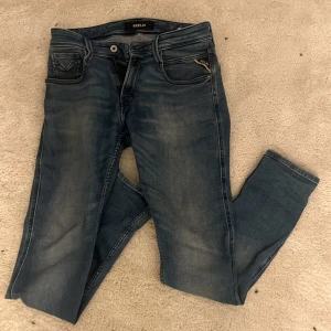 Replay Anbass blå jeans herr w29 l30 - Snygga Replay Anbass jeans i klassisk blå tvätt med lätt slitning. Modellen har fem fickor, dragkedja och raka ben. Perfekta för dig som gillar en modern och stilren look. Jeansmaterialet är mjukt och följsamt. Sicka gärna rimliga pris förslag 