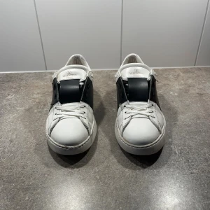 Valentino Garavani Open  - Säljer ett par valentino open i storlek 41 i färgen svart/vitt. Väldig stilren sko som har mycket kvar att ge! Lite färg släpp vid hälarna, annars mycket fint skick🤩✨. Box, dustbags och allts som kom med vid köp följes med. Hör gärna av er vid minsta lilla, äktehetsbevis finns!🤗