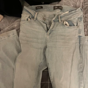 Ljusblå jeans från LTB Fallon - Säljer ett par ljusblå jeans från LTB, modell Fallon. Jeansen har klassisk femficksdesign, låg midja och dragkedja. De är tillverkade i mjukt denimtyg och har en slim passform som sitter snyggt längs benen. Perfekta för dig som gillar en enkel och fräsch look.