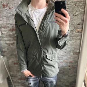 Field Jacket - Riley - Mycket fint skick, inga defekter. Storlek 52/L passar dig som är mellan 180-190cm ungefär. Nypris ca 2000kr. Modellen är 185 cm, 79 kg. Passar bra nu till vintern. Skriv för mer information!🤝
