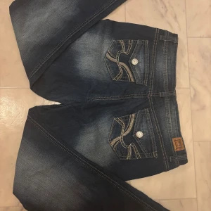 Mörkblåa low waist bootcut jeans från l.e.i med broderi och coola fickor  - Snygga mörkblåa bootcut jeans från l.e.i med broderade bakfickor och kontrastsömmar. . Modellen heter Sophie - Hipster flare och har en mer flare fit och en låg till lite midrise midja beroende på hur lång man är.                   Midjemått : 42 cm , Yttreben längd : 98cm , Inreben: 69cm 💕