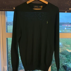 Mörkgrön merinoullströja Polo Ralph Lauren - Slim fit mörkgrön tröja från Polo Ralph Lauren i tvättbar merinoull. Tröjan är i väldigt bra skick, nästan ny. Nypris 1665 köpt i butik. Priset kan diskuteras vid en snabb affär.