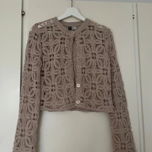 Beige virkad kofta från H&M - Superfin beige virkad kofta från h&M med lång ärm och blommönster. Kan mötas upp på Södermalm!