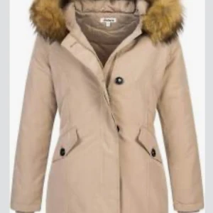 Beige parkasjacka med fuskpäls från Elara NYPRISET 1000kr - 🍁🍂Snygg beige duvnjacka från Elara med huva och fuskpäls. Jackan har långa ärmar, knappar framtill och två fickor med lock och knapp. Perfekt för kyliga dagar och har en klassisk, stilren look. Nypriset i butik:1000sek. Helt ny och oanvänd. Passa på passa på och fynda. Bra 🍂🍁💕