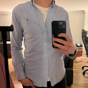 Ralph Lauren skjorta - Tjena! Säljer en riktigt snygg Ralph Lauern skjorta. Den är i bra skick 9/10. Skjortan är i färgen blå . Storlek S men passar liten M. Den är perfekt nu till våren och sommaren☀️ Nypris runt 1600 kr Hör av dig vid funderingar🙌 Modellen är 188cm 80kg och den sitter för kort. 