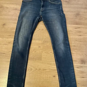 Mörkblå skinny jeans Tiger of Sweden - Snygga mörkblå jeans från Tiger of Sweden med klassisk femficksdesign och skinny passform. Jeansen har lätt slitna detaljer och är tillverkade i stretchigt denim för en bekväm känsla. Perfekta för dig som gillar en smal siluett och stilren look.