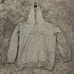 Grå hoodie från H&M Relaxed Fit XS - Grå hoodie från H&M i relaxed fit, storlek XS. Klassisk modell med huva och snörning, samt magficka framtill. Mjuk insida och ribbade muddar vid ärmslut och nederkant. Perfekt för chill dagar eller när du vill vara extra bekväm. Passar även S/M 