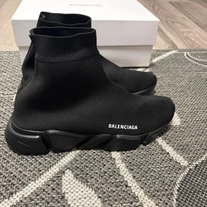 Balenciaga Speed Trainer sneakers svarta - Svarta Balenciaga Speed Trainer sneakers med stickad ovandel i stretchig syntet och chunky svart sula. Strumpliknande passform och vit Balenciaga-logga på sidan. Riktigt clean och futuristisk vibe, perfekt för dig som gillar statement sneakers.