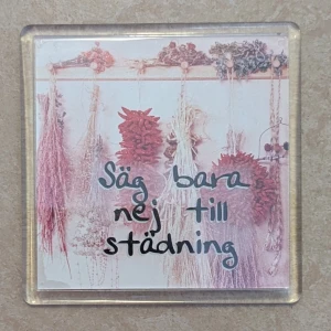 Magnet 'Säg bara nej till städning' - Rolig kylskåpsmagnet med texten 'Säg bara nej till städning' och bild på torkade blommor. Tillverkad i EU, copyright 1998. Magneten är i gott skick med lättare bruksspår på baksidan. Perfekt som present eller dekoration till köket.