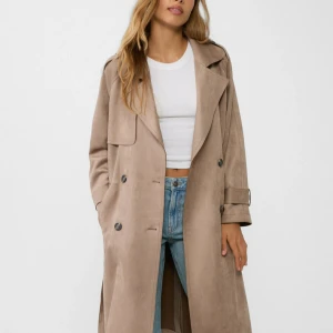 Beige trenchcoat med bälte - Snygg beige trenchcoat från Stradivarius i mjukt material. Jackan har klassisk krage, knappar framtill, bälte i midjan och långa ärmar med spänndetaljer. Perfekt för lager-på-lager och en chill look.