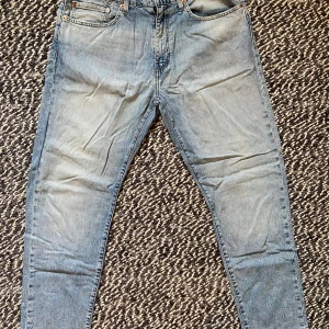 Levi's 502 ljusblå jeans W34 L32 - Ljusblå Levi's 502 jeans med klassisk femficksdesign och snyggt slitna detaljer. Jeansen har rak passform och normal midja, tillverkade i bomull. Perfekta för en avslappnad och stilren look. Sparsamt använda så superfint skick. Ostrukna på bilden.
