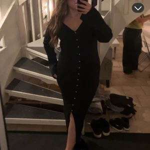 Stickad klänning  - Svart stickad klänning med guldknappar från hm