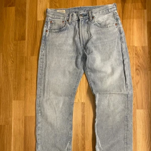 Levi's  ljusblå jeans loose fit - Säljer ett par Ljusblå Levi's jeans väldigt billigt för att jag vill bli av med dem snabbt. De har klassisk lös passform och femficksdesign. Jeansen har en snygg och unik slitning på bakfickan och är tillverkade i 100% bomullsdenim. Perfekta för en avslappnad och tidlös stil.