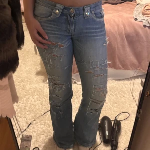 Ljusblå slitna bootcut jeans - Midjemått: 36 cm innerbebslängd: 82