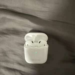 Apple AirPods (2nd generation) - Apple AirPods 2nd gen och laddas med Lightning sladd. Dem fungerar parfeckt. Mer frågor kan ställas!