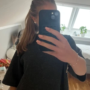 Mörkgrå stickad tröja med kort ärm - Säljer en mörkgrå stickad tröja med rund hals och korta, breda ärmar💗💗