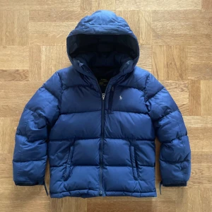 Ralph lauren jacka - Säljer denna riktigt snygga blåa jackan från Ralph lauren! Den är i bra skick men har en lagning på ryggen som syns på sista bilden, storlek l (14-16) vilket motsvarar xs, hör gärna av dig vid frågor!