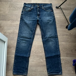 Blå jeans från Nudie - Snygga blå jeans från Nudie Jeans med klassisk femficksdesign. Modell: gritty jackson, färg: blue state (från hemsidan). Modellen har raka ben. Knappt använda. Toppskick. Storlek 29/30, hör av dig vid frågor