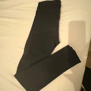 Svarta skinny byxor från Vero Moda - Svarta byxor från Vero Moda i skinny fit med klassisk femficksdesign och dragkedja. Byxorna är tillverkade i stretchigt material för en bekväm passform och har en stilren look som passar till många olika outfits.